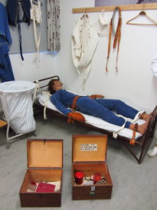Photo 10: Fixation was used as a means to calm upset and aggressive patients, to keep them from roaming, but also as a punishment. The boxes in the front contain personal belongings.